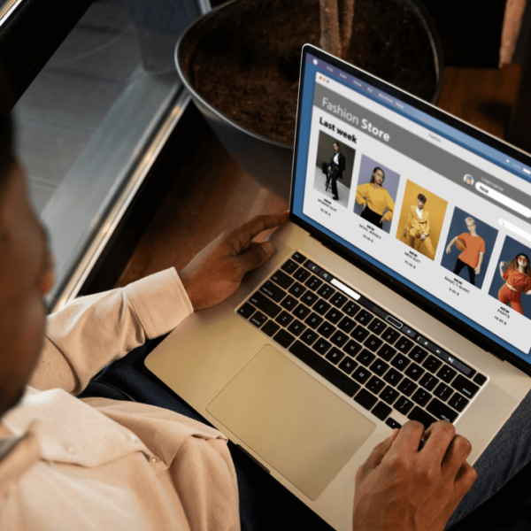 photo of a man holding a laptop and working on an E-commerce Website Maintenance